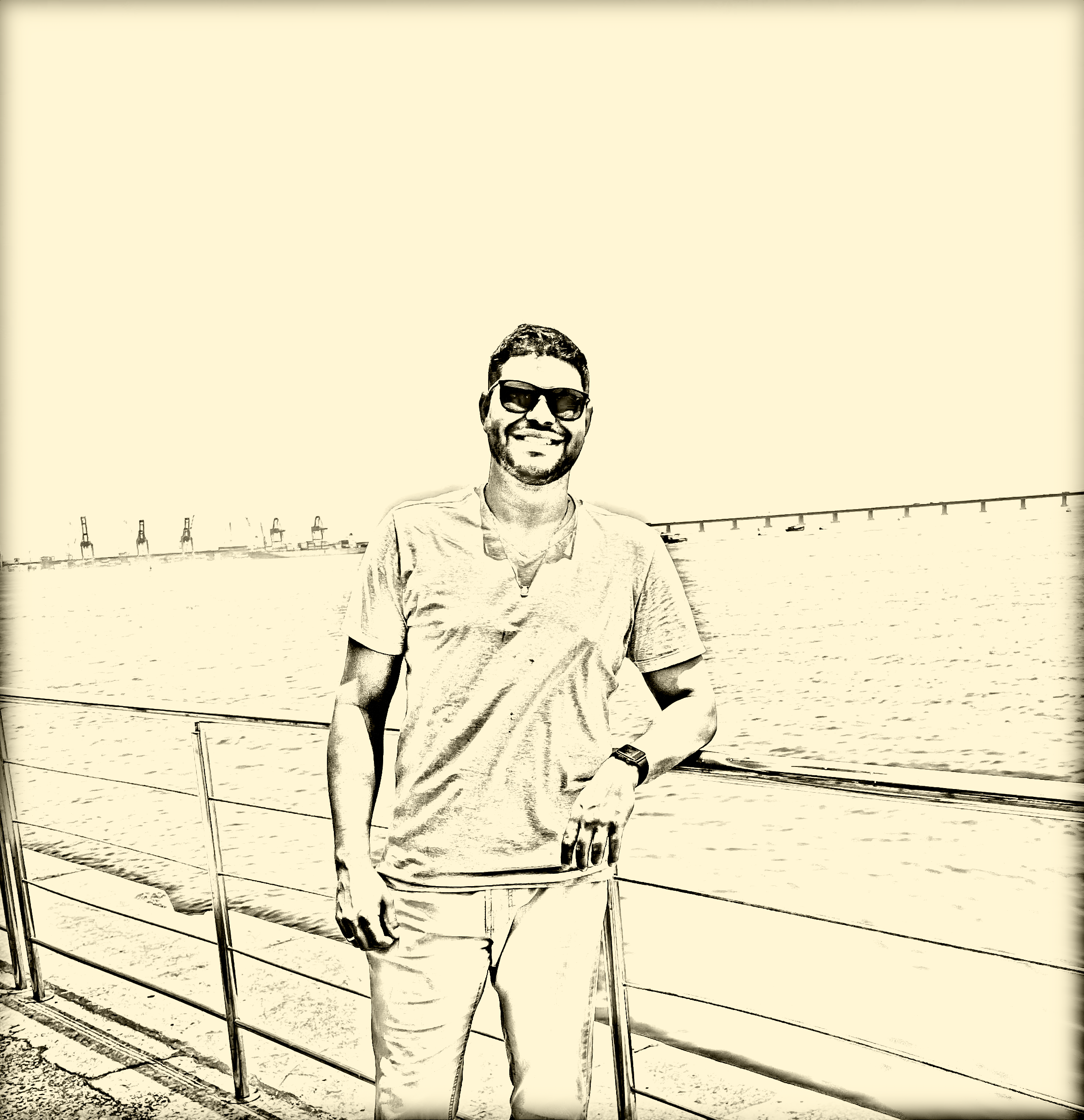 Homem em pé sorrindo em um pier de um porto.